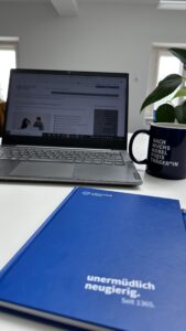 Bild einer Lernsituation inkl. Notizbuch, Laptop und einer Kaffeetasse
