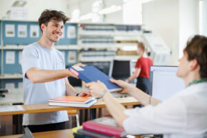 Ein Studierender borgt gerade ein Buch aus