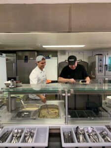 Foto von Denny und dem Koch am Kochen