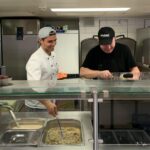 Foto von Denny und dem Koch am Kochen