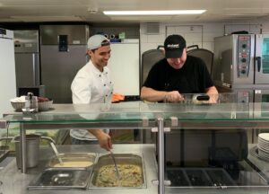 Foto von Denny und dem Koch am Kochen