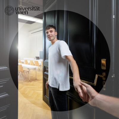 Human of #univie Lukas geht durch eine offene Tür in einen Seminarraum, dabei hält er lächelnd die Hand einer Person außerhalb des Bildes.